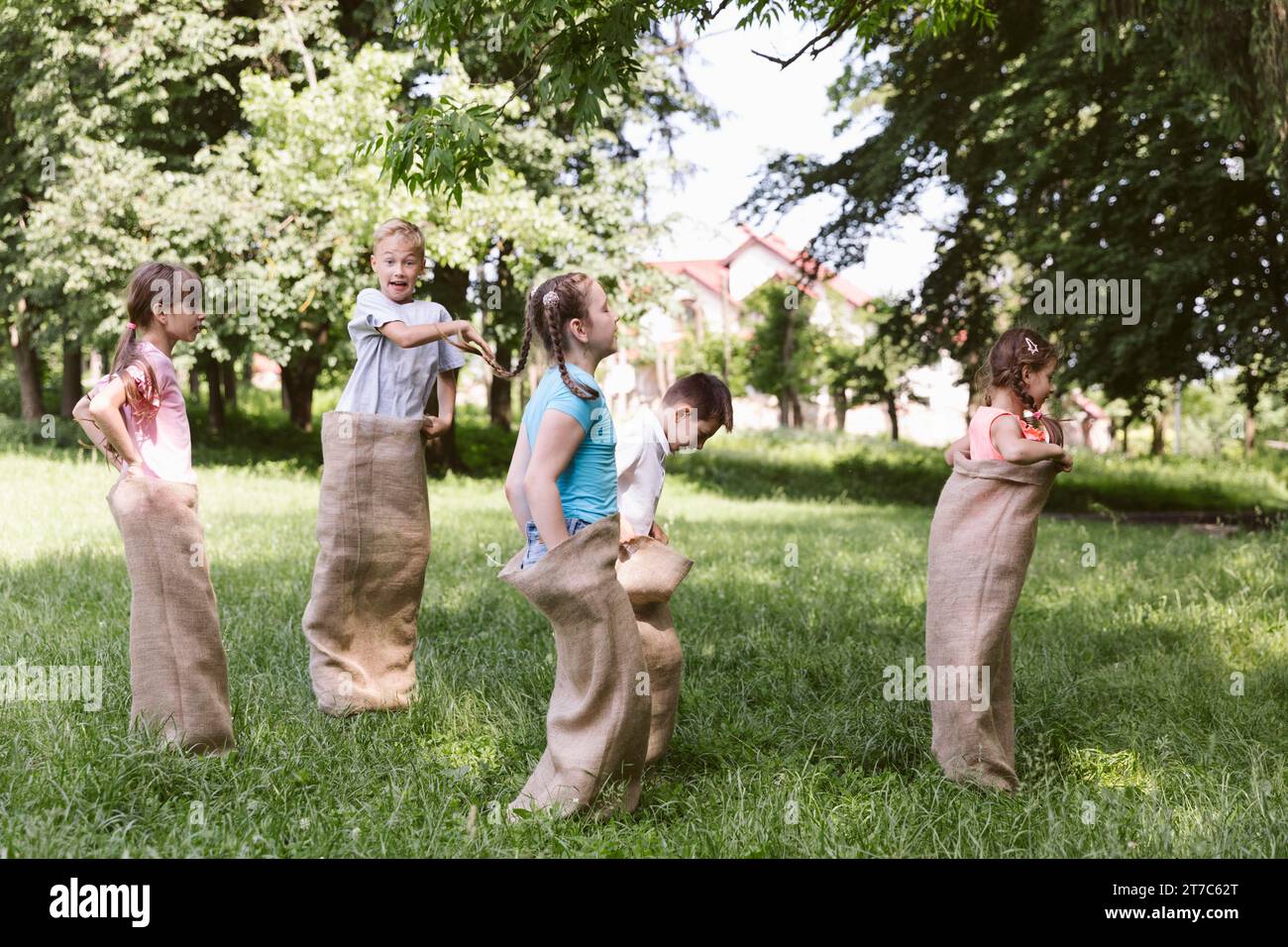Children running burlap bags Stock Photo