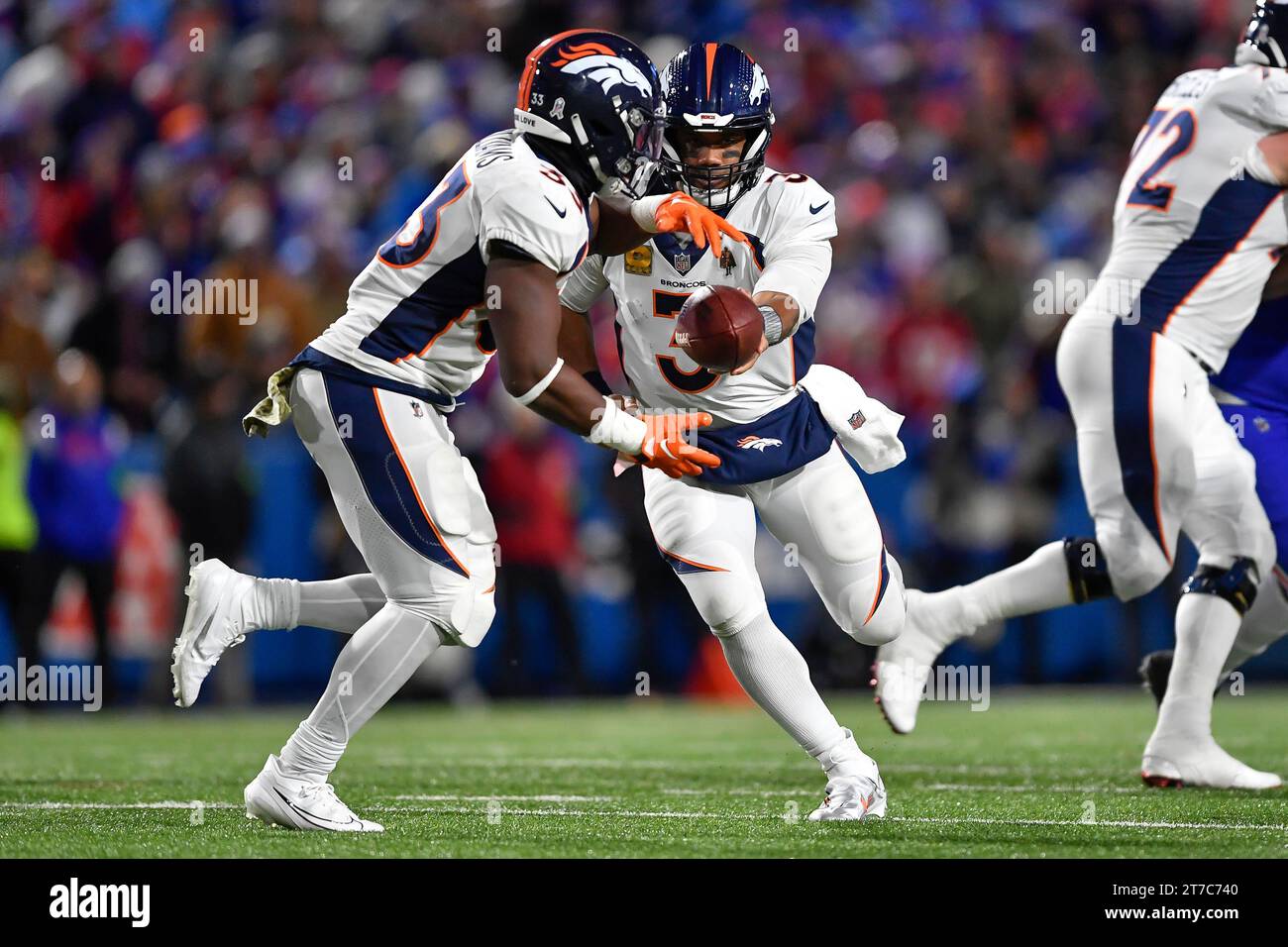 Denver Broncos quarterback Russell Wilson, right, hands the ball to ...