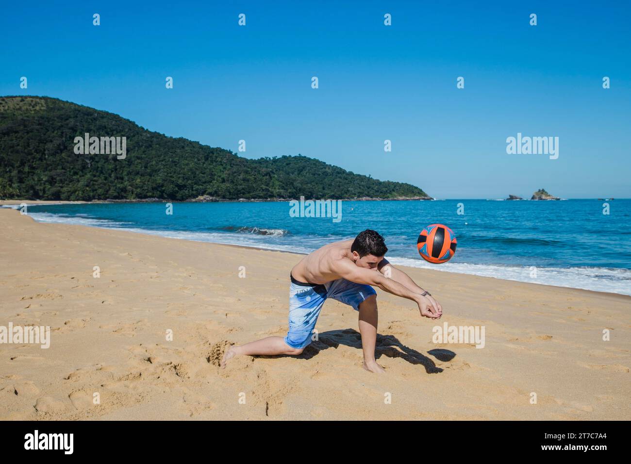 Man playing volleyball shoreline Stock Photo