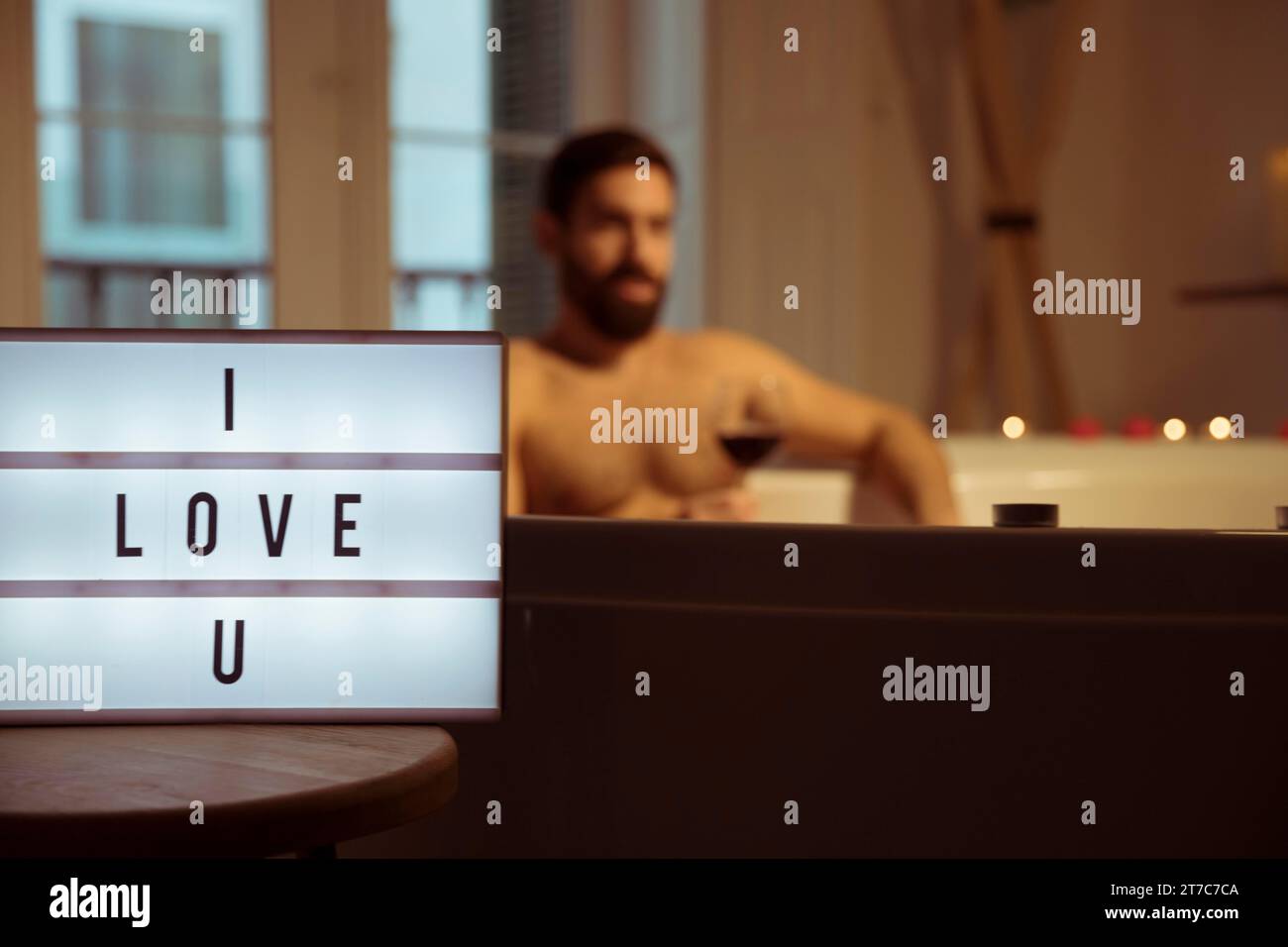 Man with glass drink spa tub i love u title lamp Stock Photo