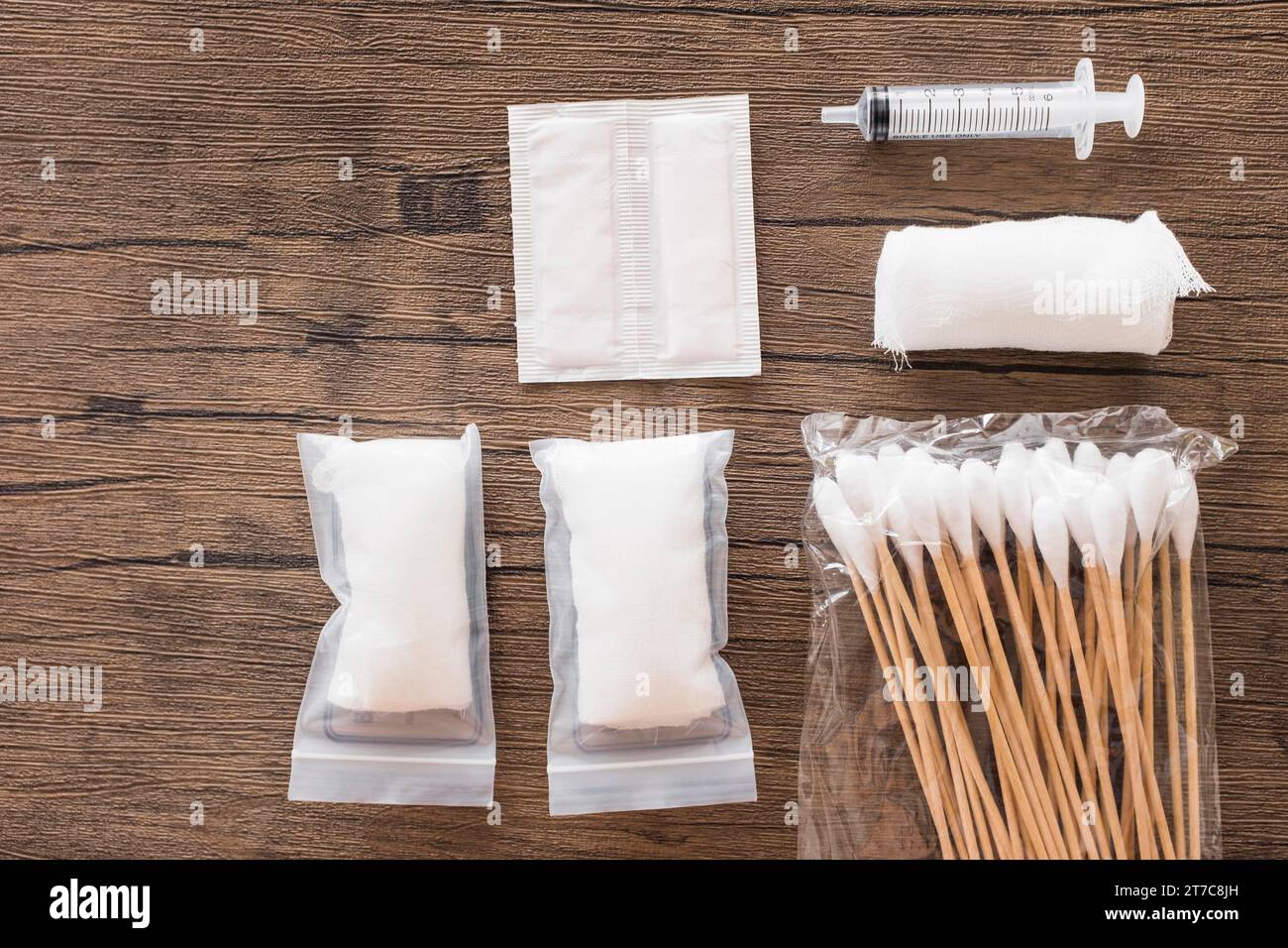 White medical cotton gauze bandage syringe pack cotton swab wooden table Stock Photo