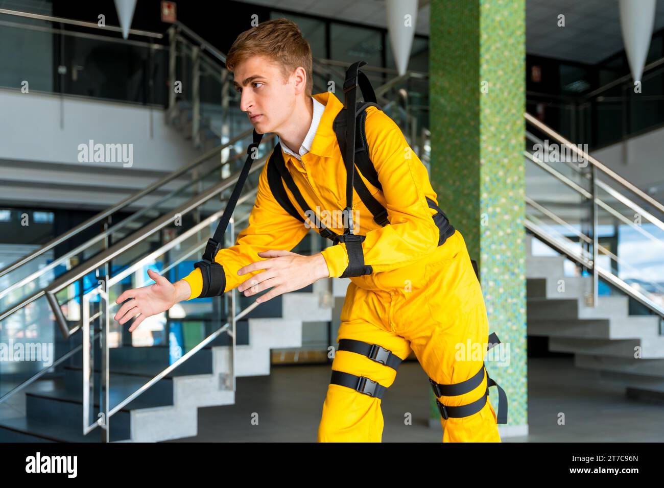 Employee with an exoskeleton from a futuristic high-tech warehouse, stretching to test the suit, help to improve injuries, futuristic physiotherapy Stock Photo