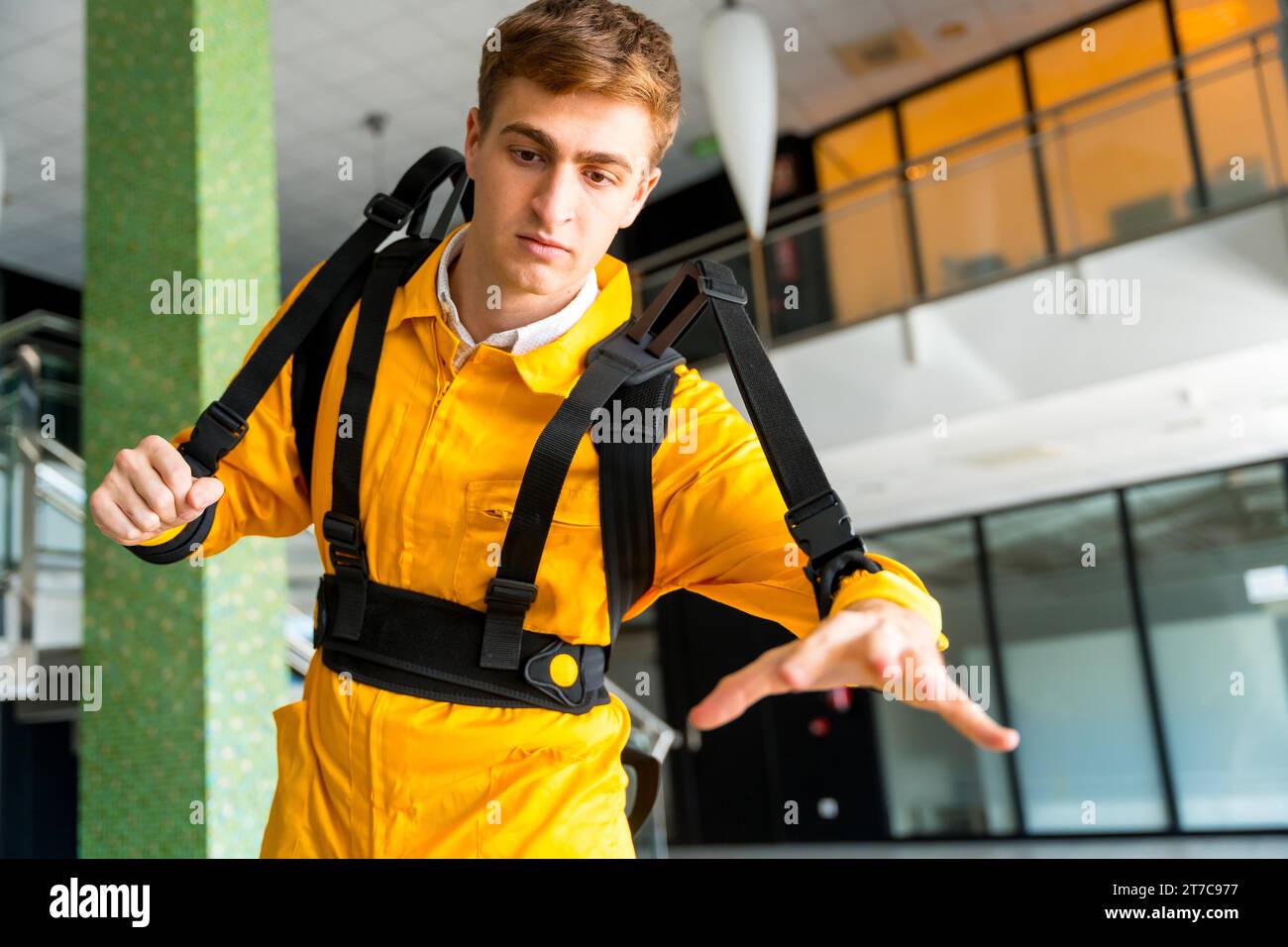 Employee with an exoskeleton from a futuristic high-tech warehouse, stretching to test the suit, help to improve injuries, futuristic physiotherapy Stock Photo