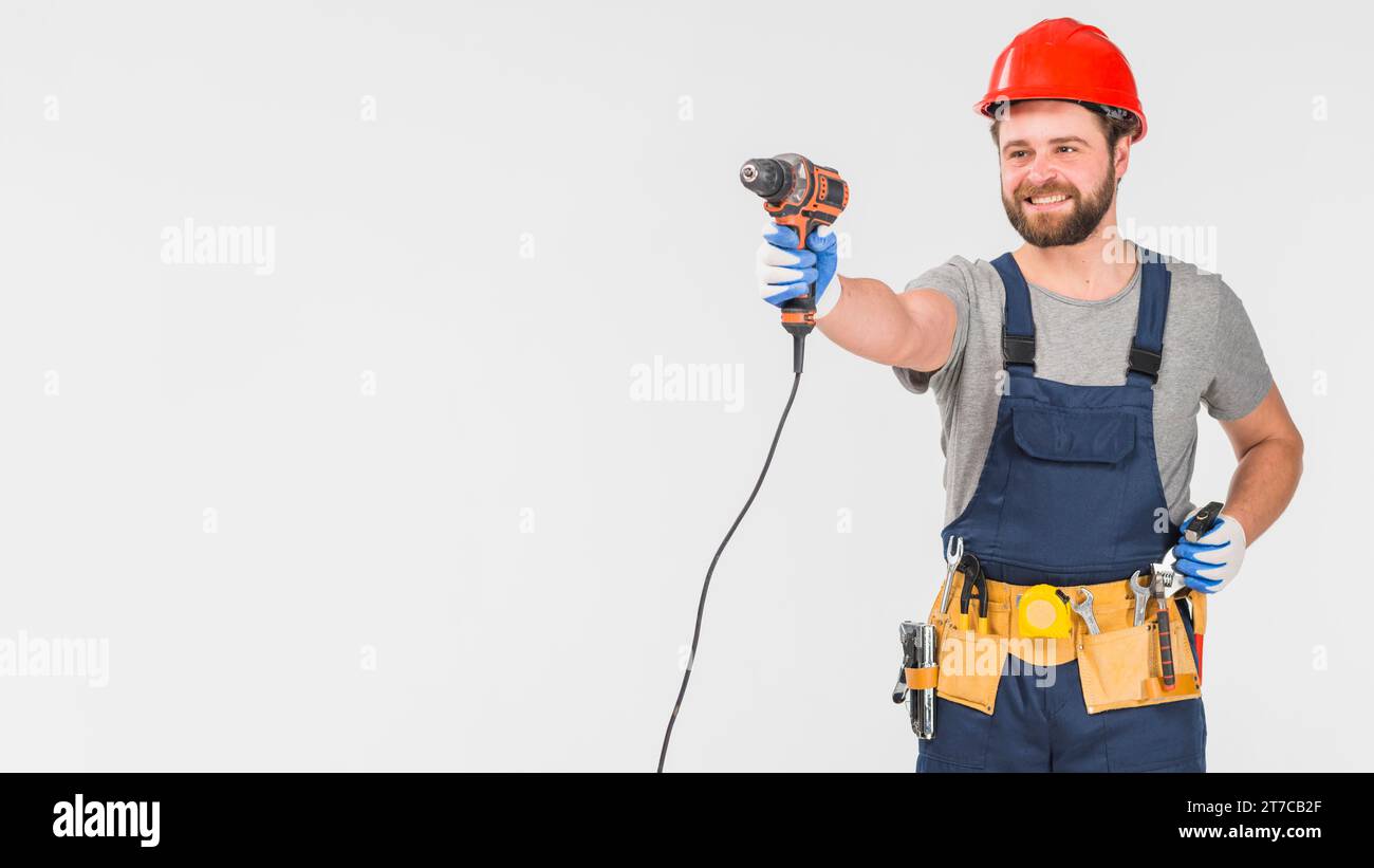 Happy repairman overall holding drill hand Stock Photo