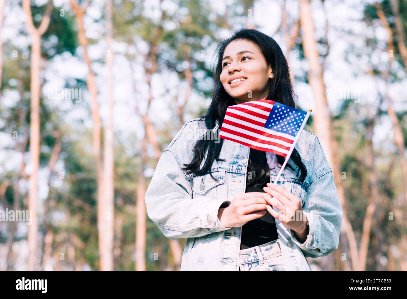 Hispanic teenage girl holding american flag stick Stock Photo - Alamy