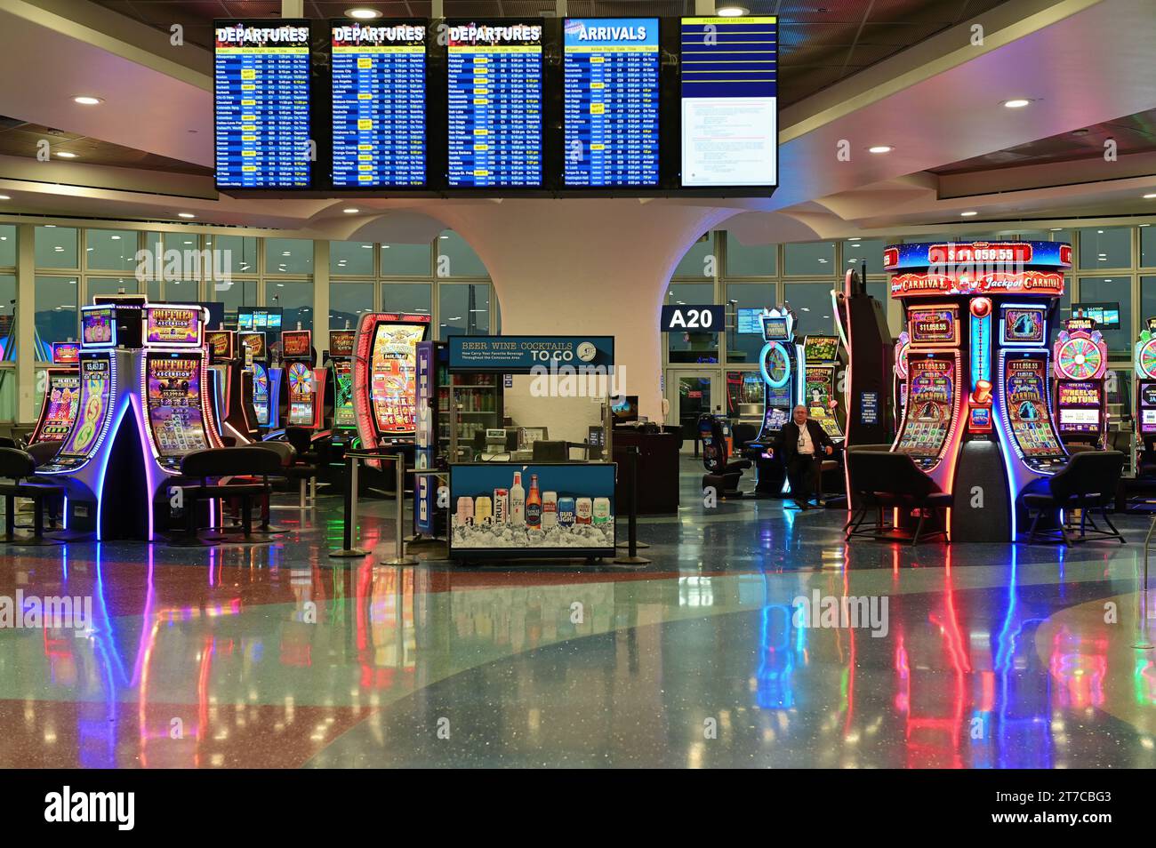 Las Vegas, Nevada, USA. Flight information monitors mingle with gaming machines at gate areas at Harry Reid International Airport. Stock Photo