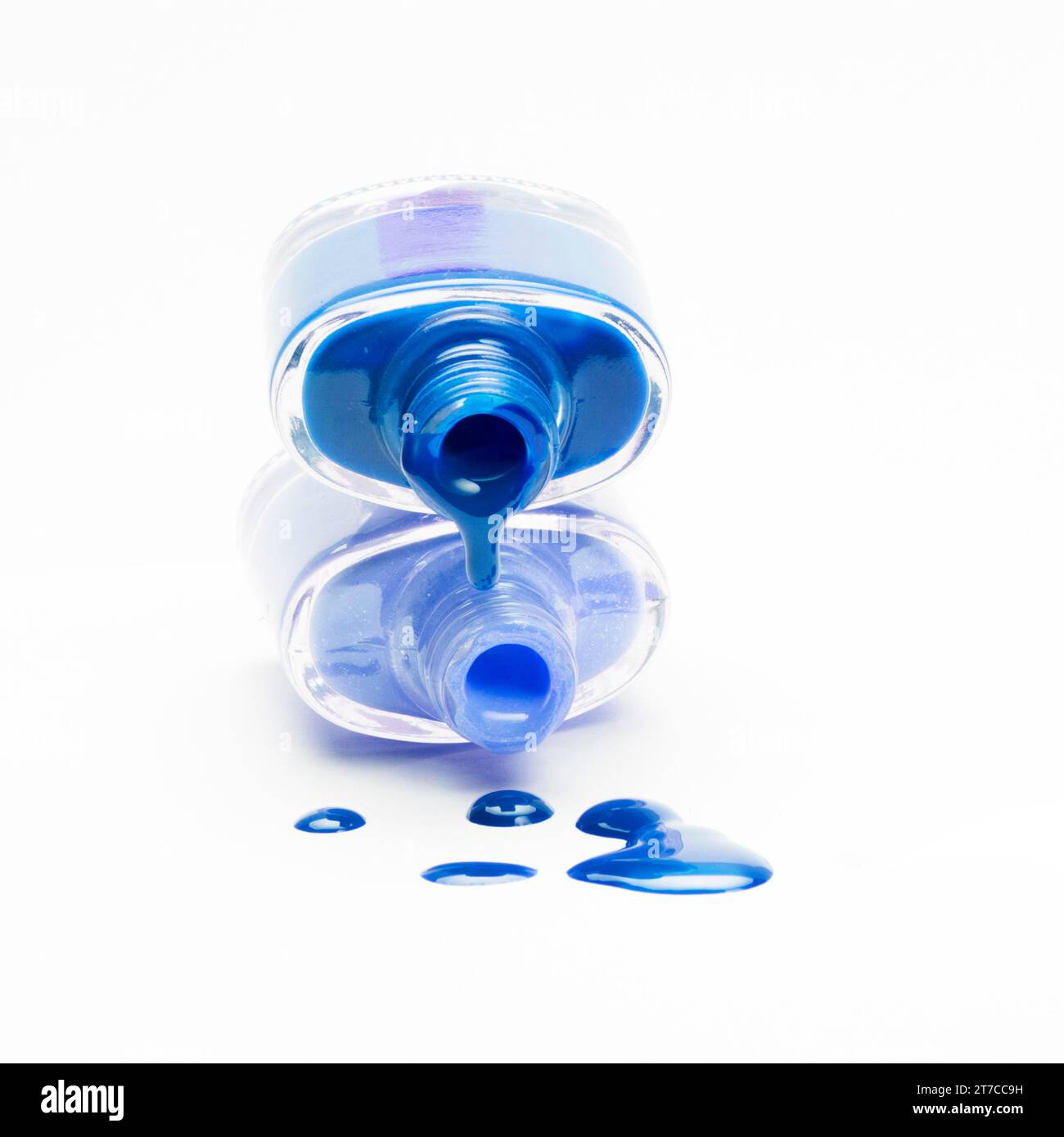 Stacked blue nail polish dripping white backdrop Stock Photo