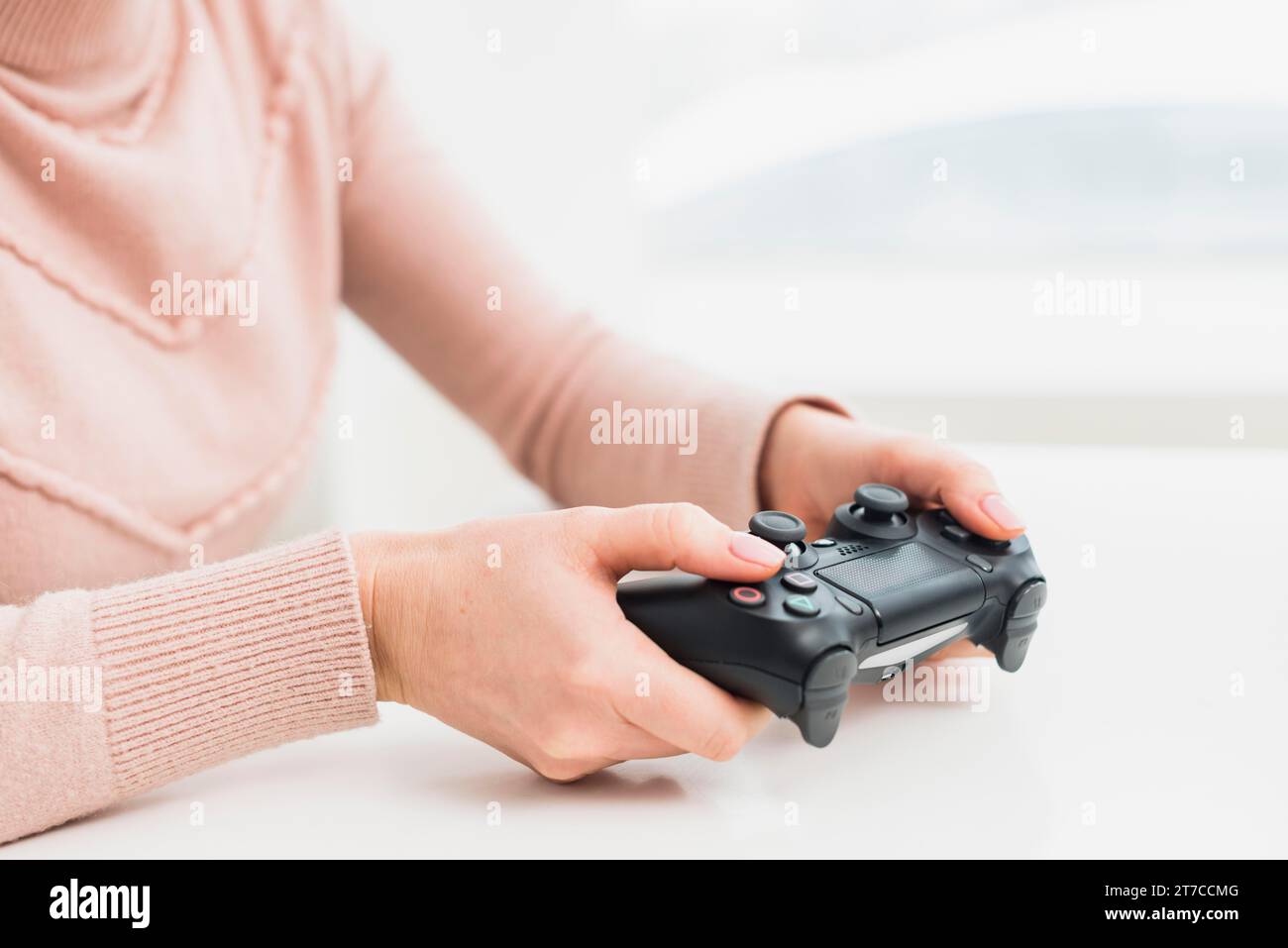 Woman pink clothes playing game console Stock Photo