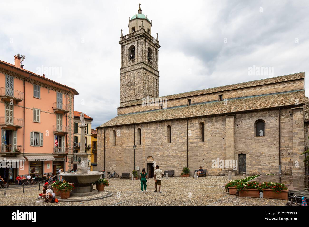 The 12th century Basilica of Saint James stands beyond a fountain in the church square in Bellagio, Lombardy, Italy. Stock Photo