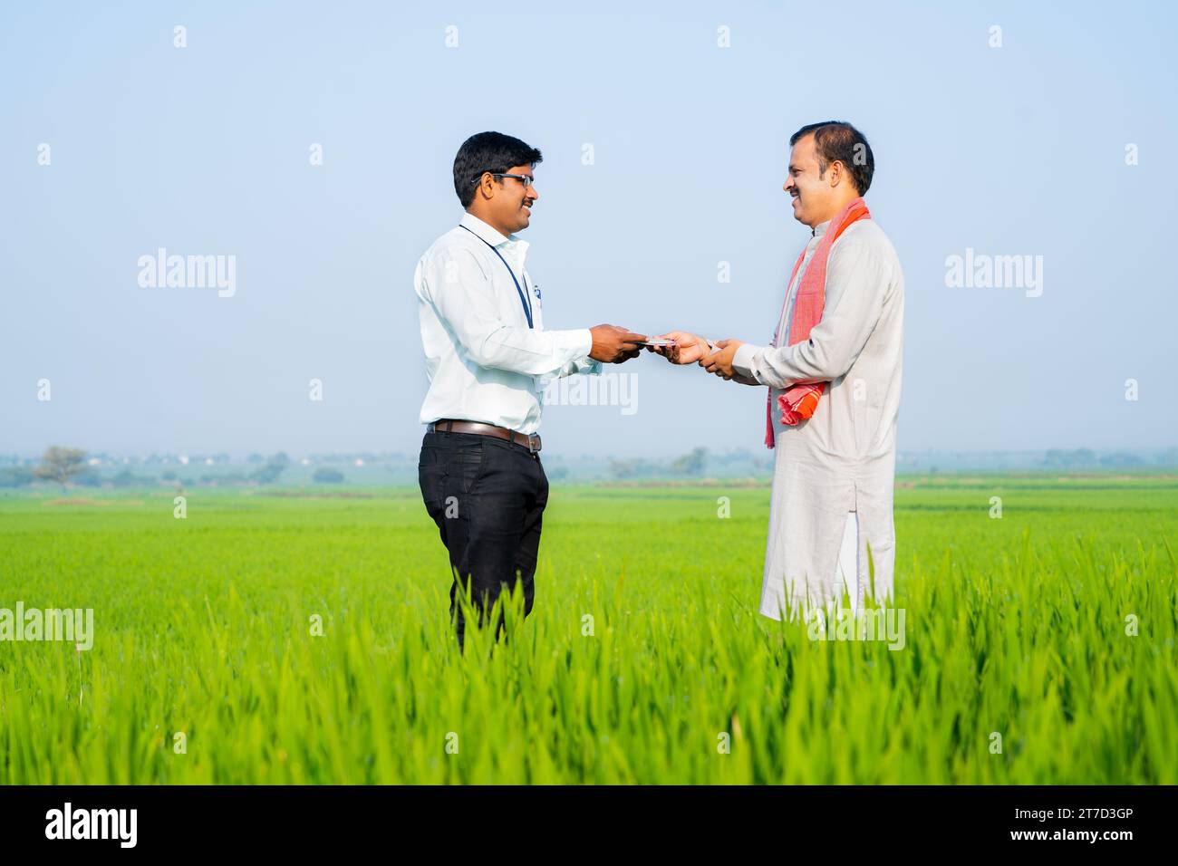 wide shot Happy indian banker giving money to village farmer at green