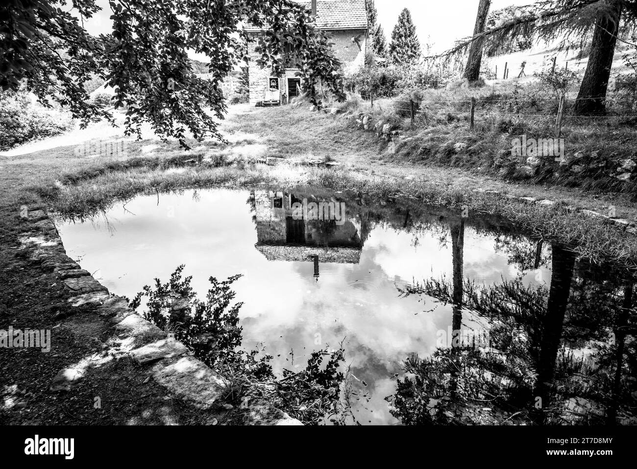 small hut in the alps reflected on the alpine lake in Tonezza del Cimone vicenza Italy Europe Stock Photo