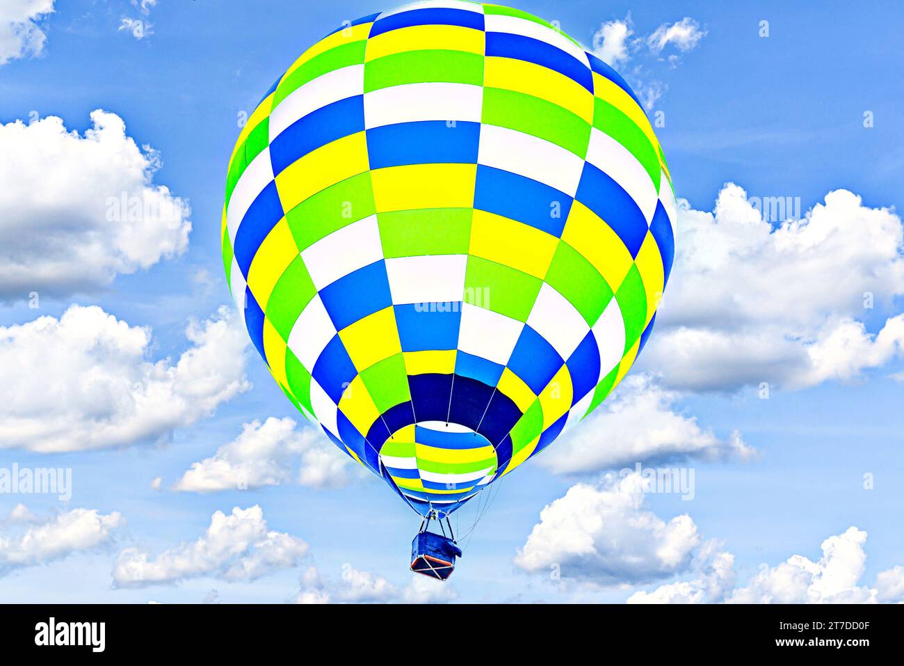Colorful hot air balloon flying over blue sky with white clouds Stock ...