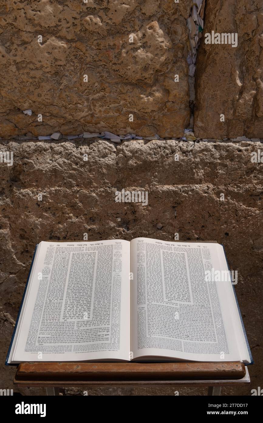 A Talmud open to the text from the tractate Ketubot rests on a prayer stand in front of the Western Wall in Jerusalem. Stock Photo