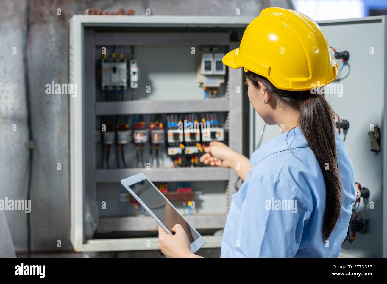 Electrician Engineer woman working check service maintenance electricity main circuit fuse and power system in industry factory Stock Photo