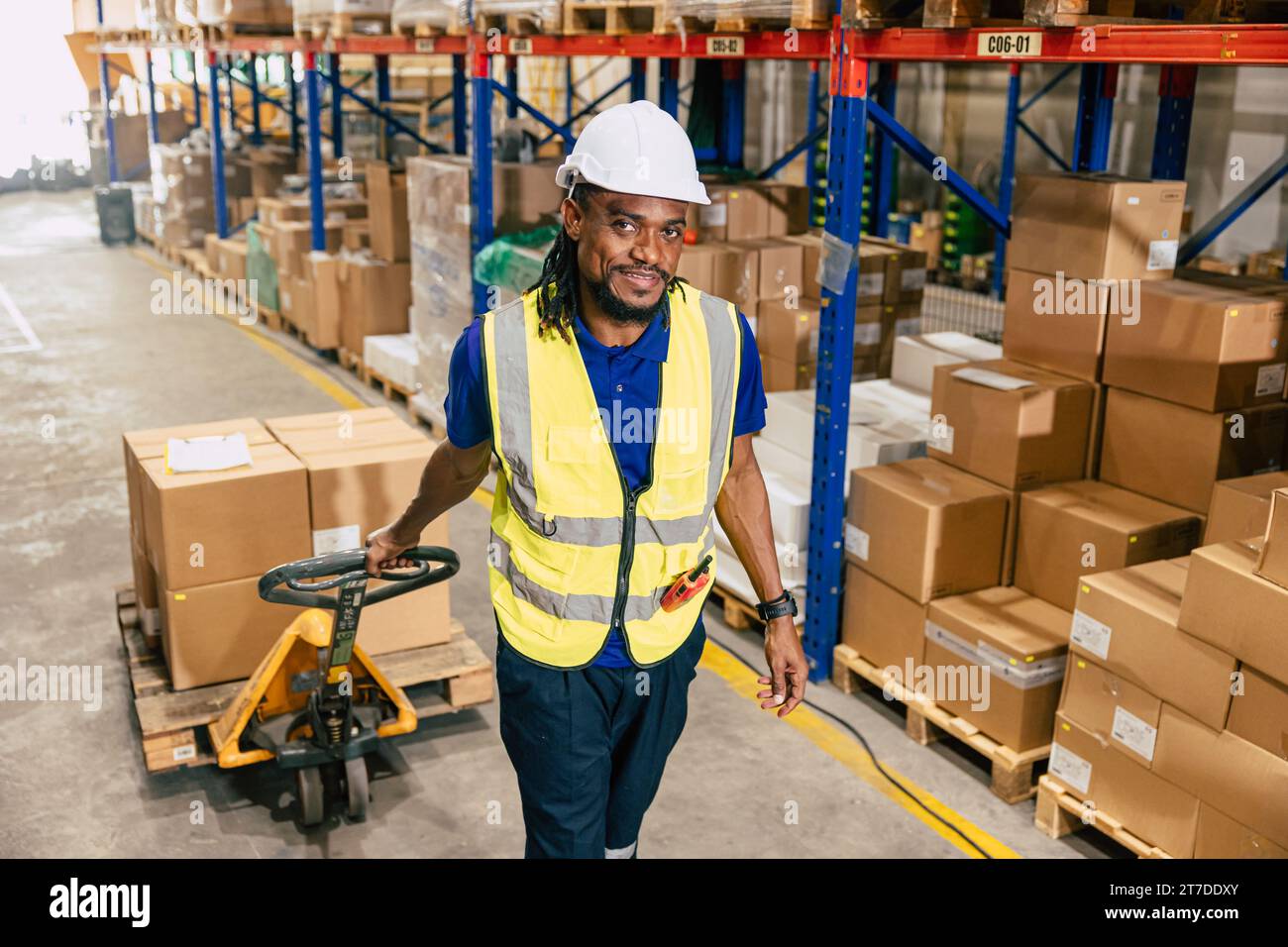 african black warehouse worker using parcel pallet moving cargo for logistics shipping supply management industry Stock Photo