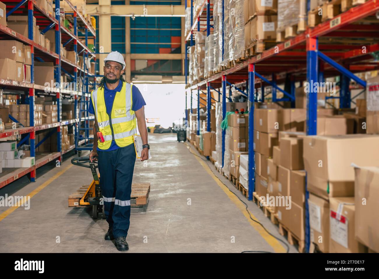 african black warehouse worker using parcel pallet moving cargo for logistics shipping supply management industry Stock Photo