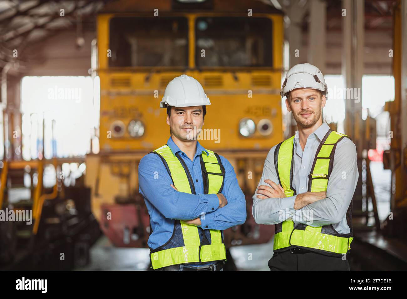 Portrait engineer two men standing in locomotive train depot friend technician team worker smart condident employee. Stock Photo