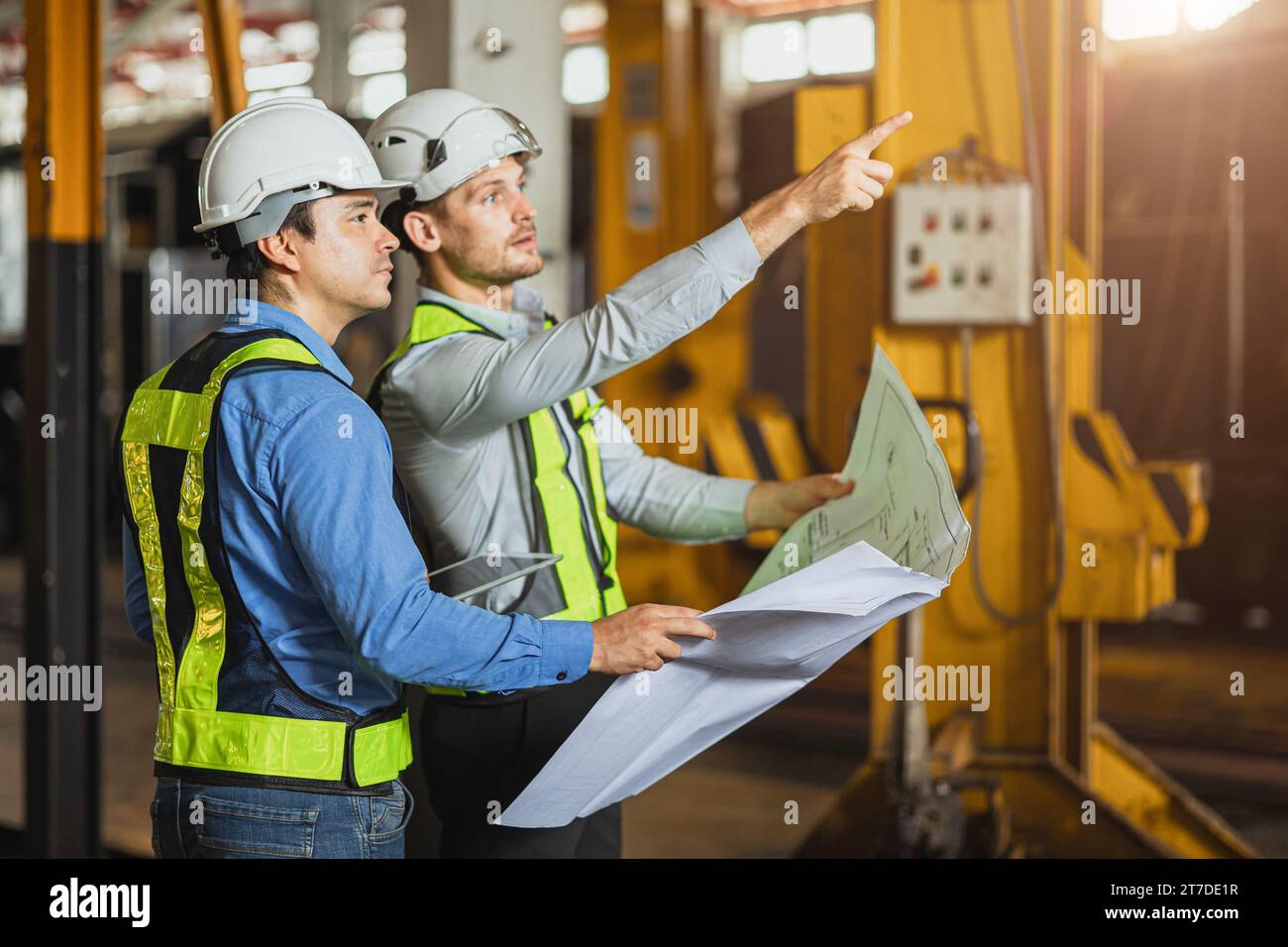 Construction engineer with technician designer team working build site inspect for interior renovate in industry workshop building with floor plan. Stock Photo
