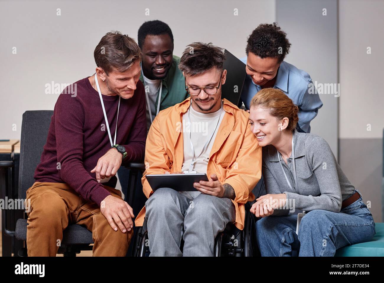 Businessman with disability working on tablet pc together with his colleagues Stock Photo