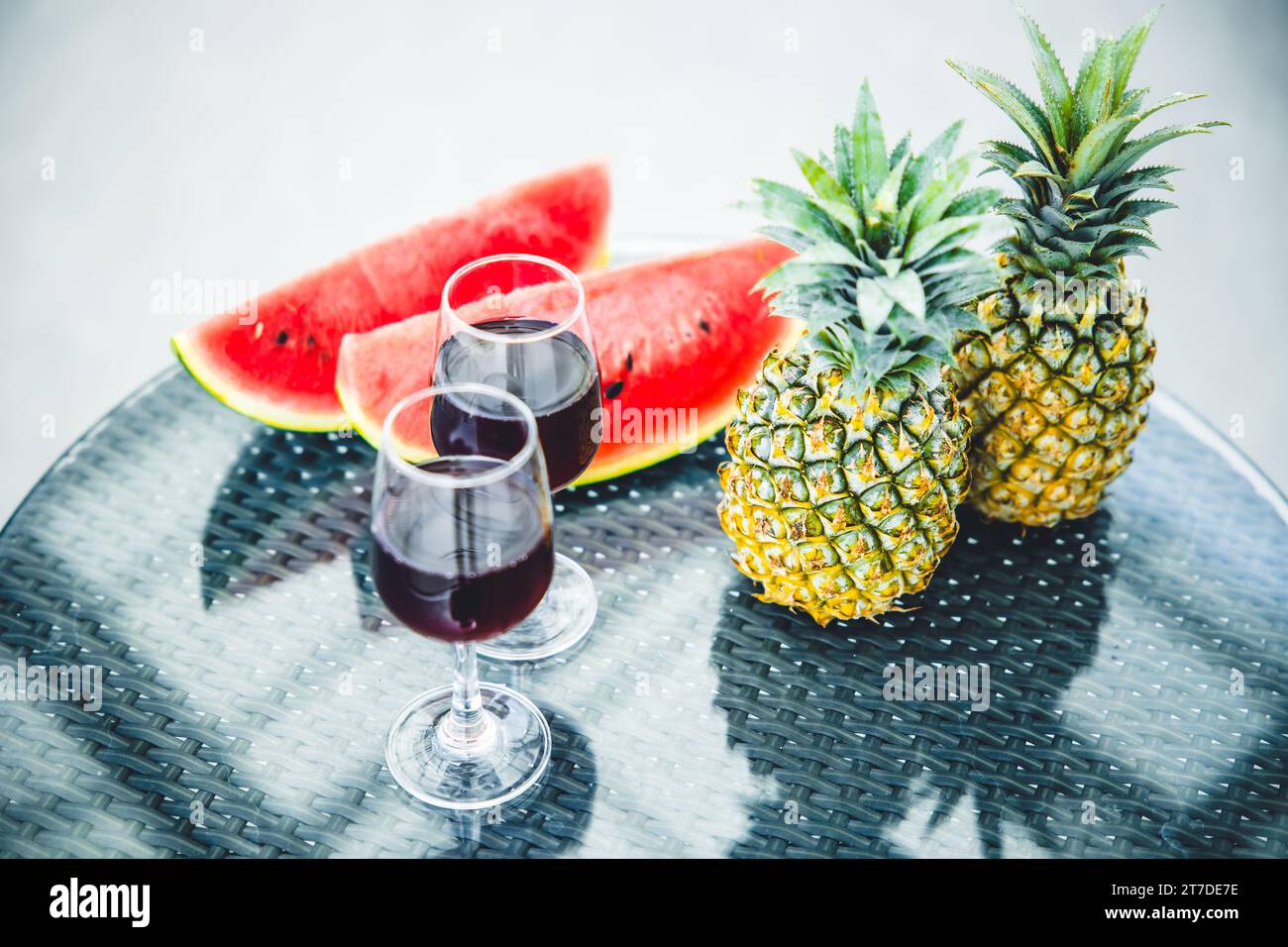 Tropical fruits with wine glasses at hotel closeup for travel holiday vacation at sea beach ocean island concept. Stock Photo