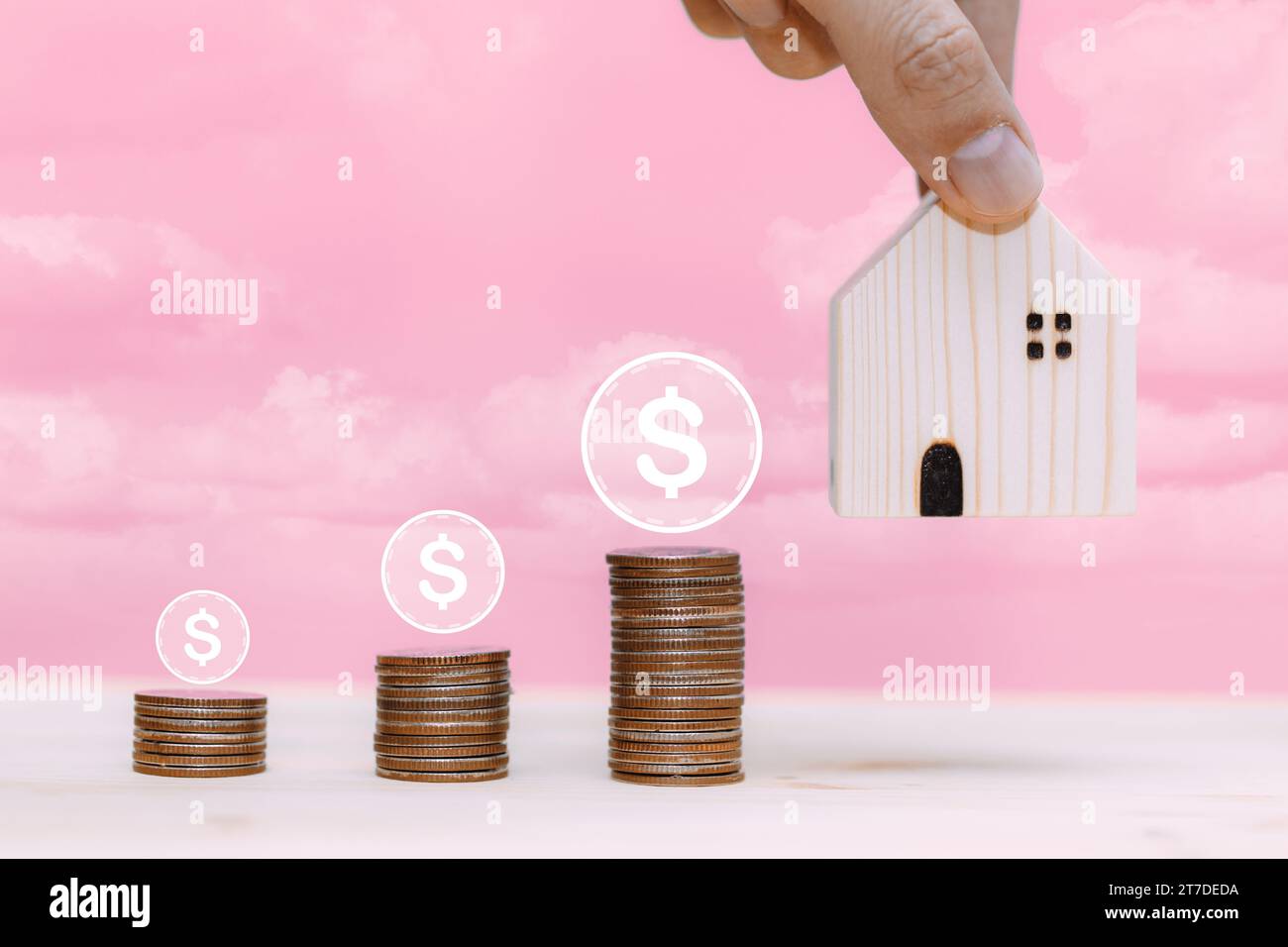 hand pick home model with money stacked for saving money for buying or moving to new house concept Stock Photo