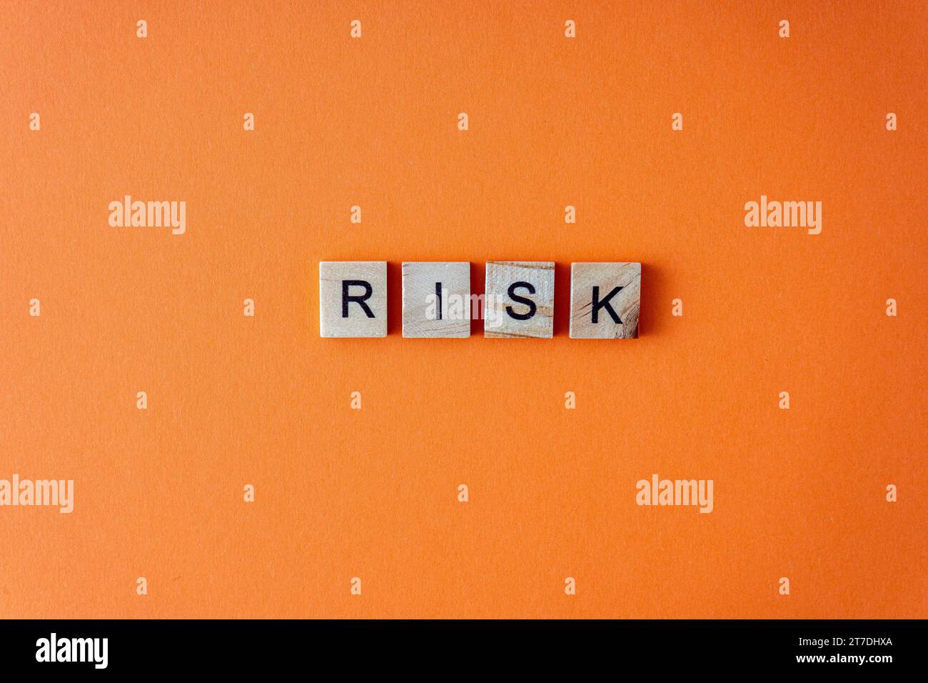 Word risk. The phrase is laid out in wooden letters top view. Orange ...