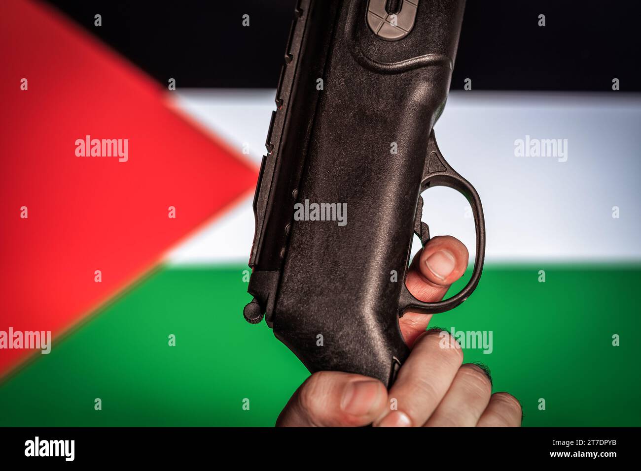 Israel vs Palestine war concept. Man holds an gun. Palestine flag on background.war concept Stock Photo