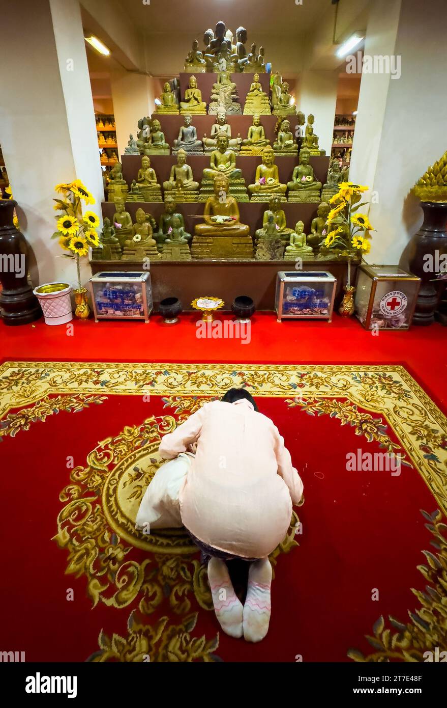 A woman prays at a Buddhist shrine within Phnom Preah Reach Troap at Oudong Temple in Kandal Province near Phnom Penh, Cambodia. Stock Photo