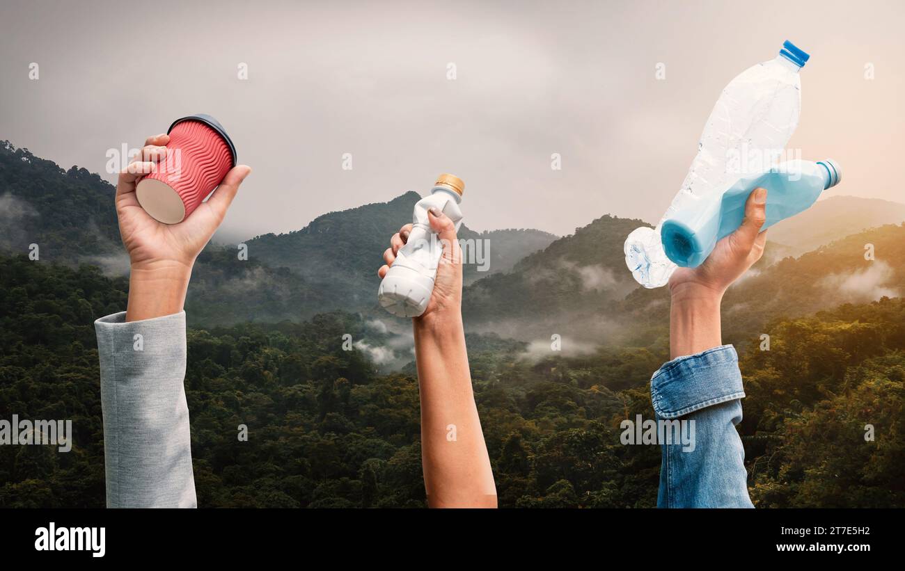 People holding various types of garbage on top of the mountain Stock Photo