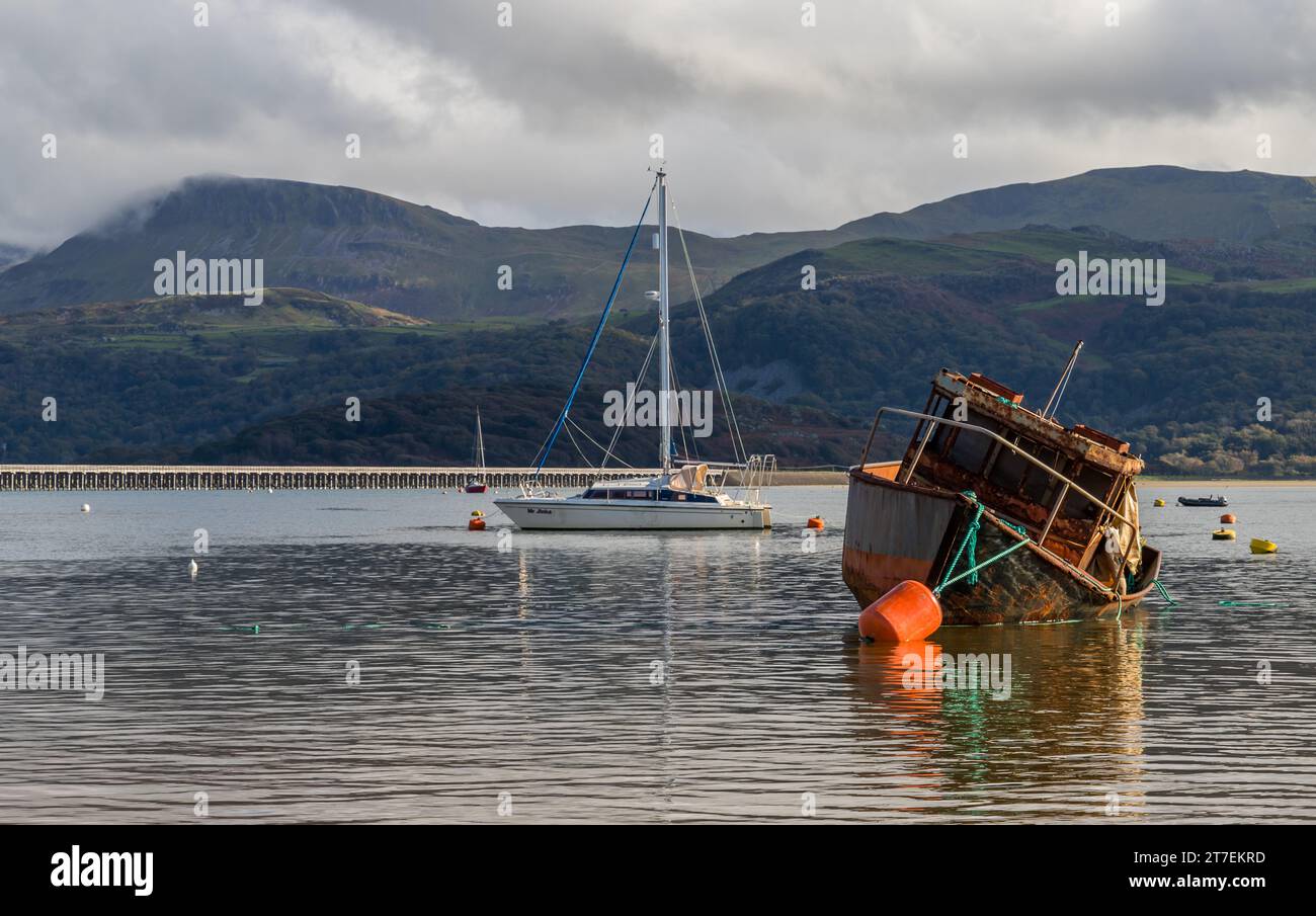 Two moored boats seen in Barmouth Harbour with the famous Barmouth Bridge in the background, taken 22nd Oct 2023. Stock Photo