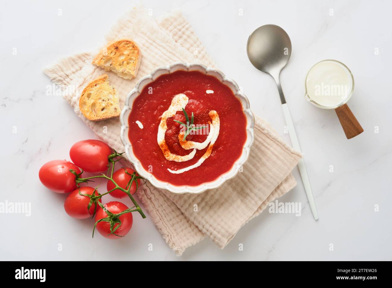 Soup. Tomato cream soup or gazpacho with herbs, seasonings, cherry tomato and parsley in white bowl on light grey stone background. Healthy vegetable Stock Photo