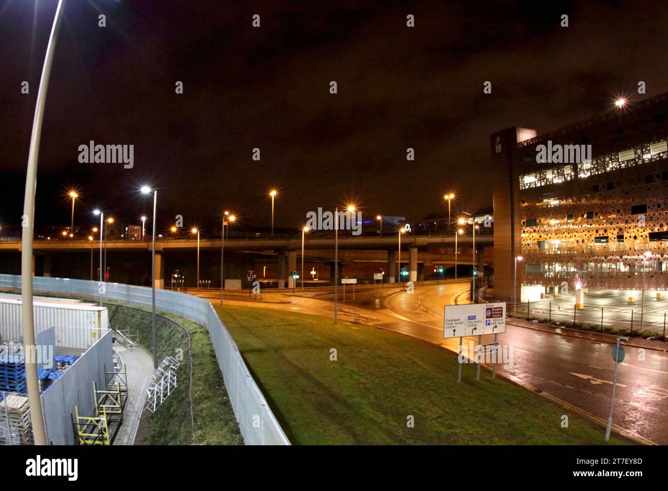 night shot of a road in finnieston in glasgow with street signs, lamp posts and car park in view. Stock Photo