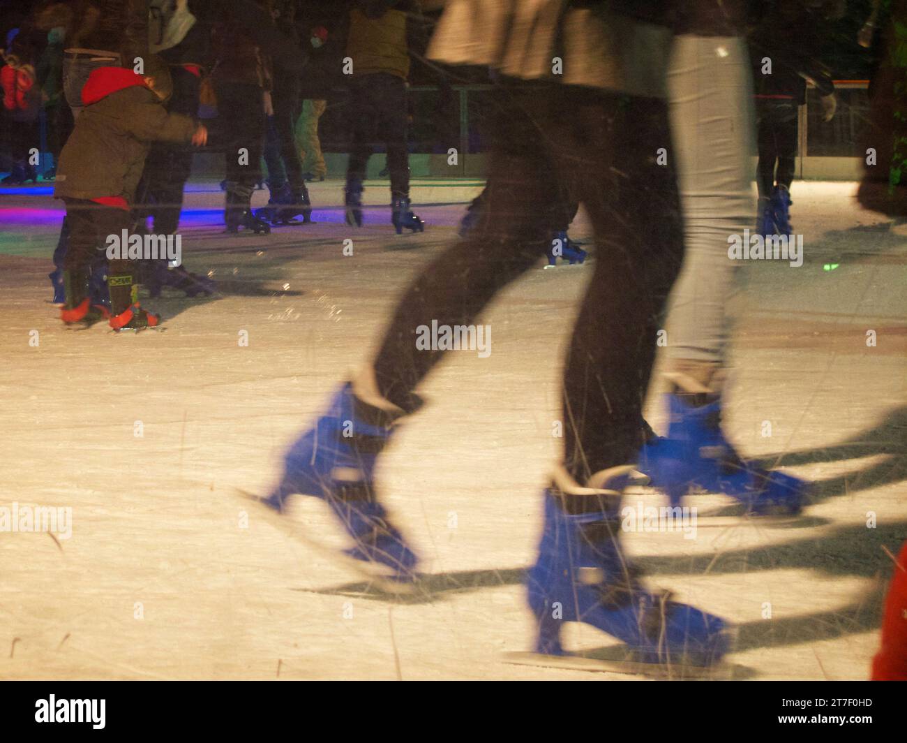 picture showing peoples legs while skating on the outdoors ice rink