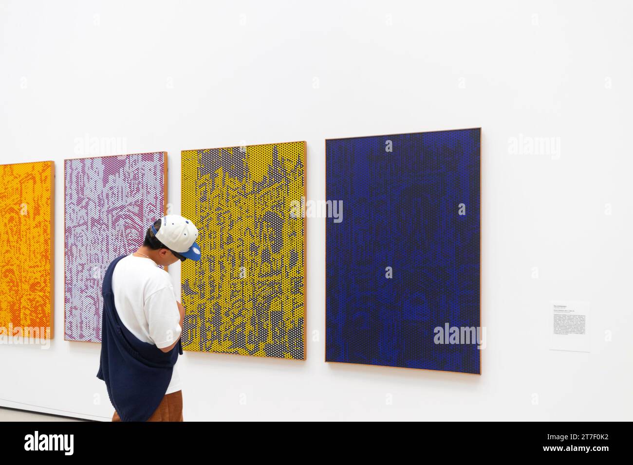 man in ball cap studying modern abstract art Lichtenstein paintings in the Broad art gallery los angeles Stock Photo