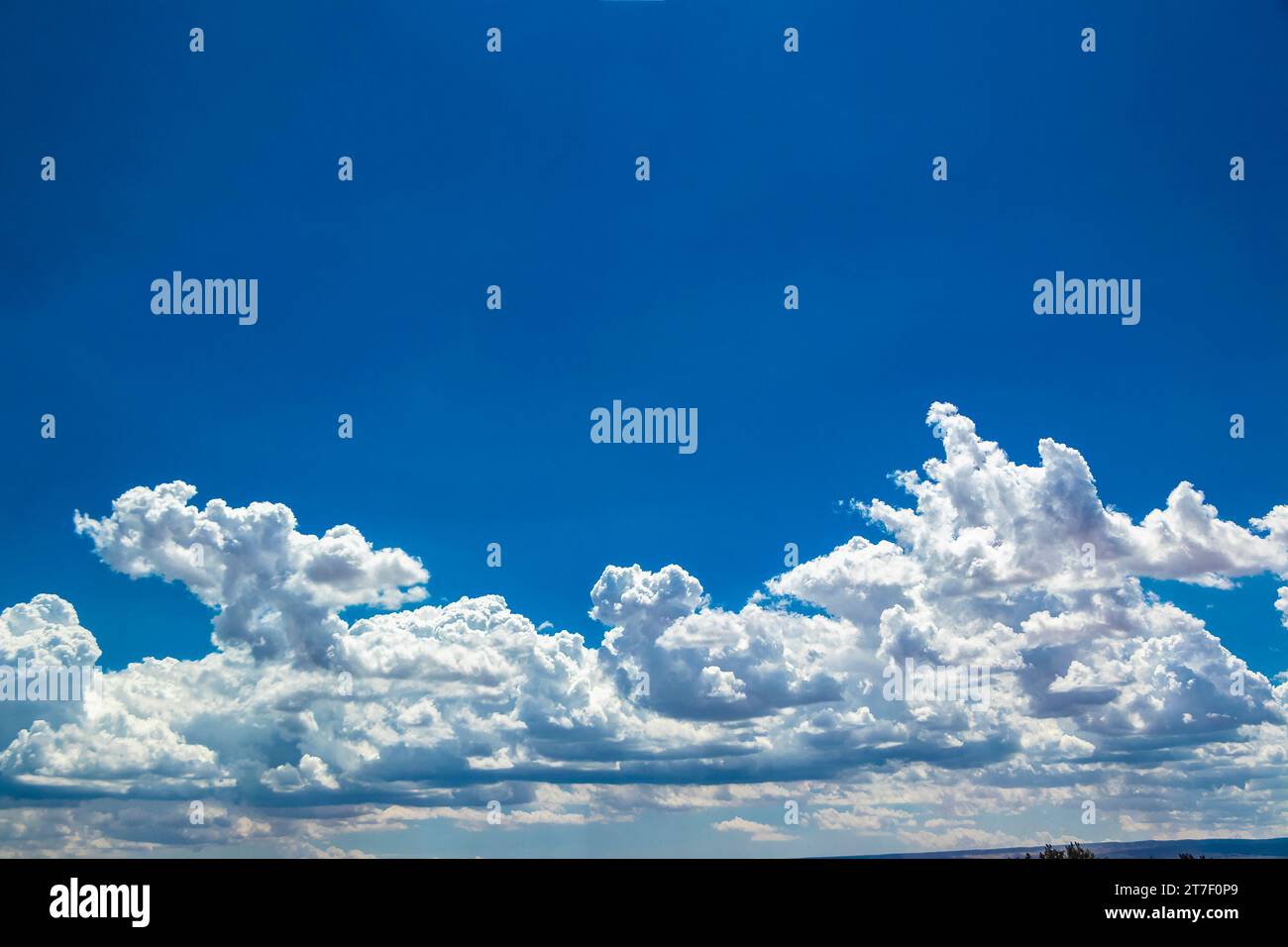 sunlit clouds in a bright blue sky Stock Photo