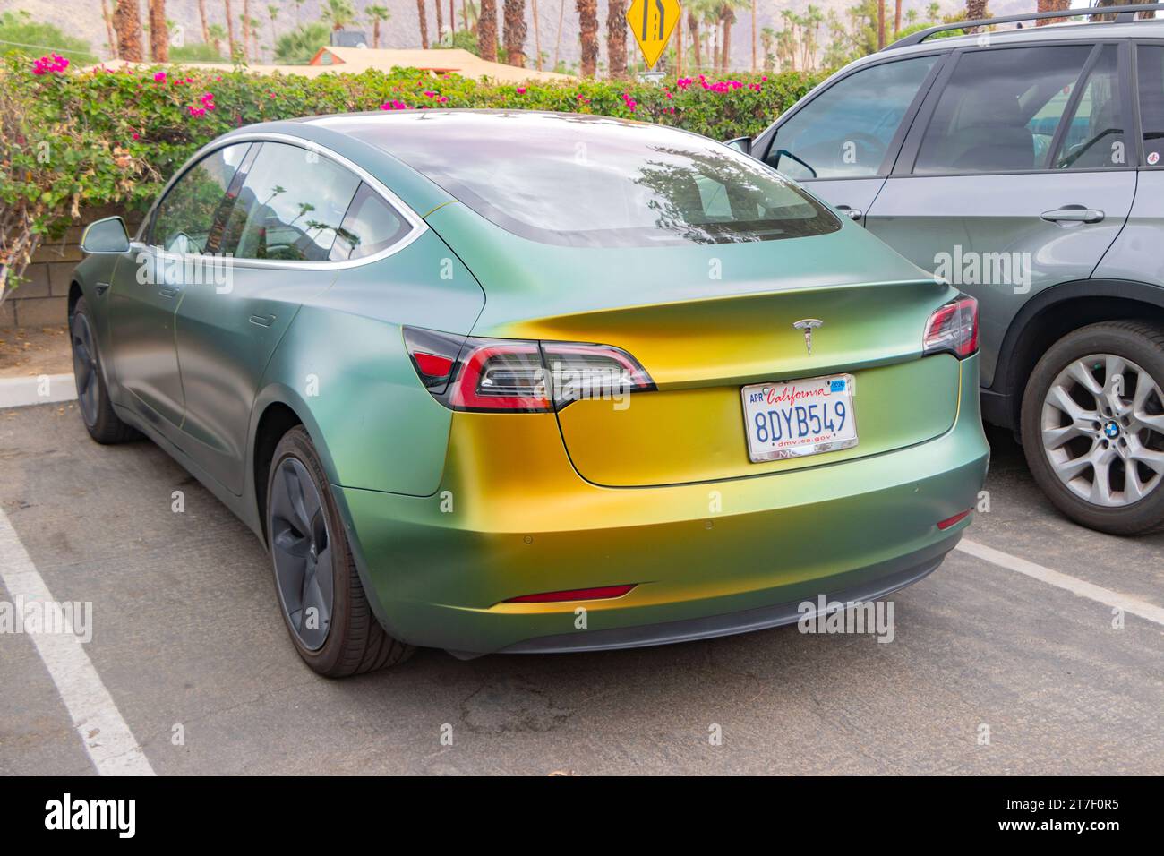 rear view green and yellow satin flip paint job on Tesla 3 car Stock