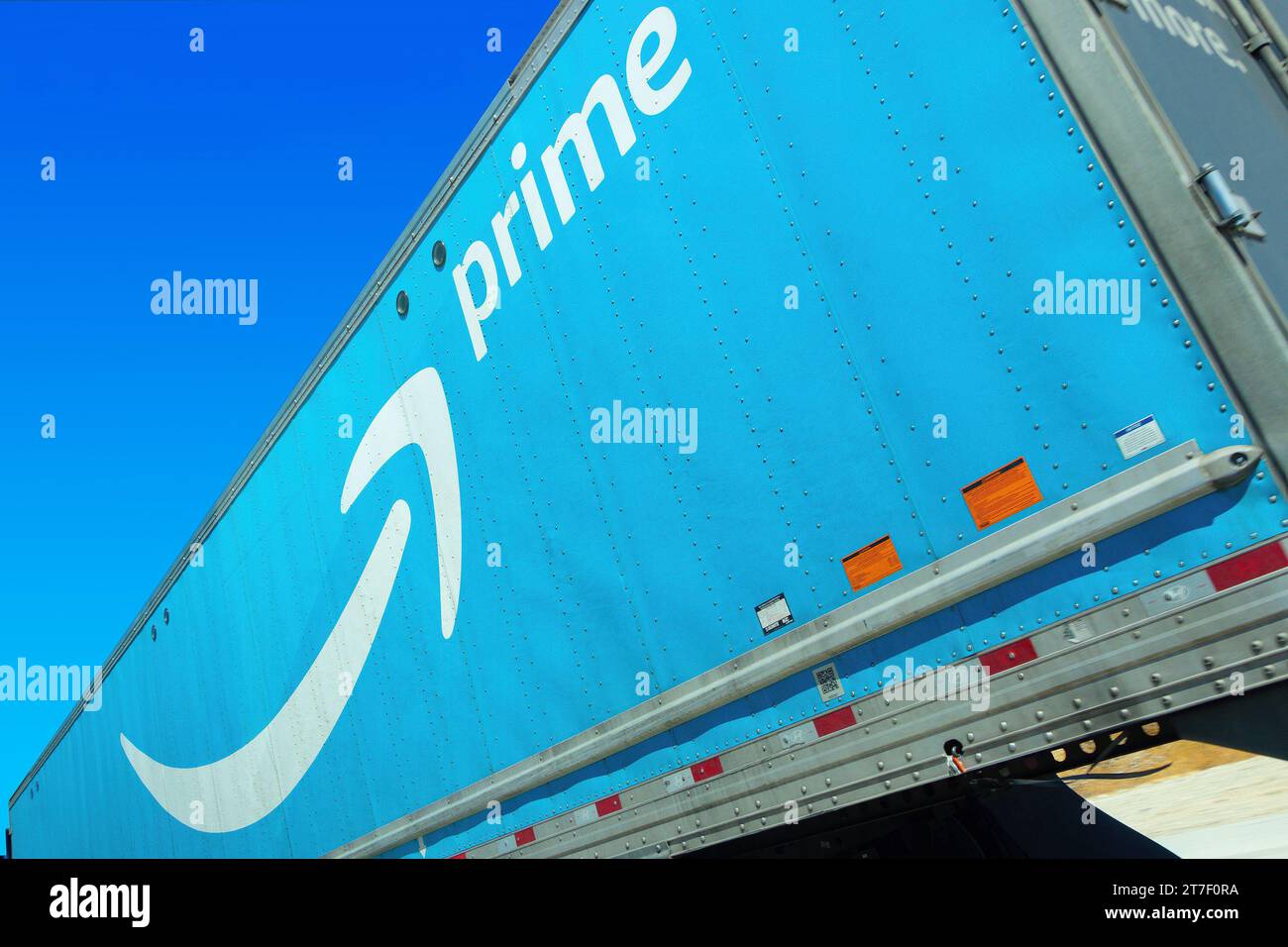 looking up dynamic angle Amazon Prime logo on side of truck on freeway Stock Photo
