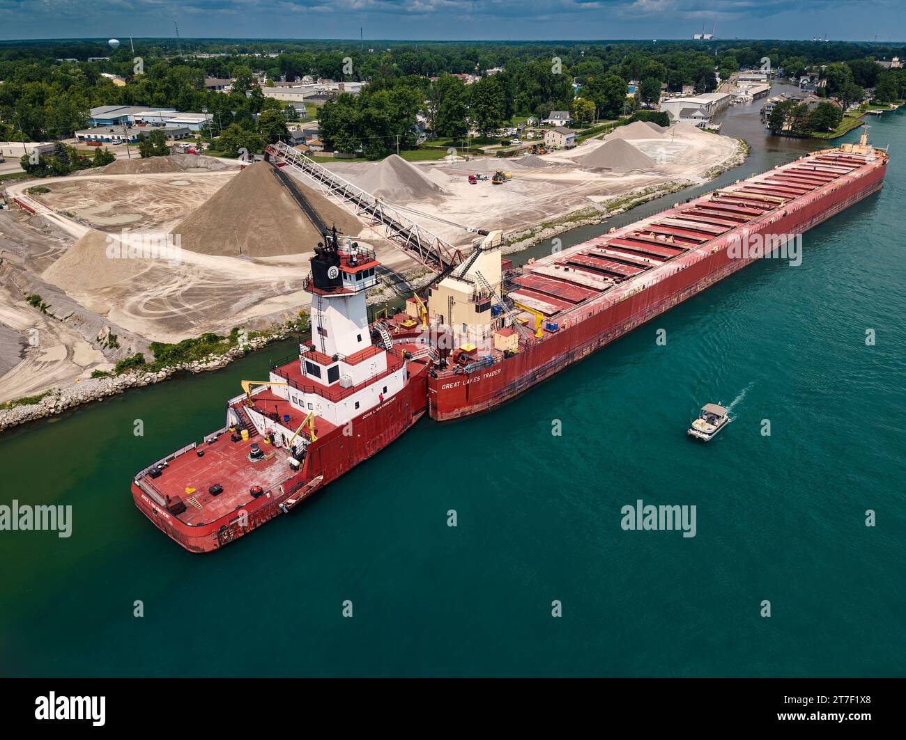 Pusher Tug Joyce L. VanEnkevort and Great Lakes Trader barge off-loading aggregate, St. Clair River, Marine City, Michigan, USA Stock Photo