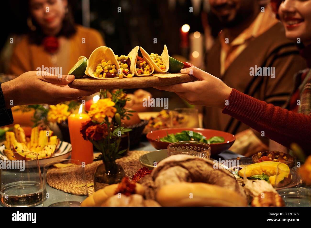 Close-up of people sitting at table and eating traditional food during celebration of holiday Stock Photo
