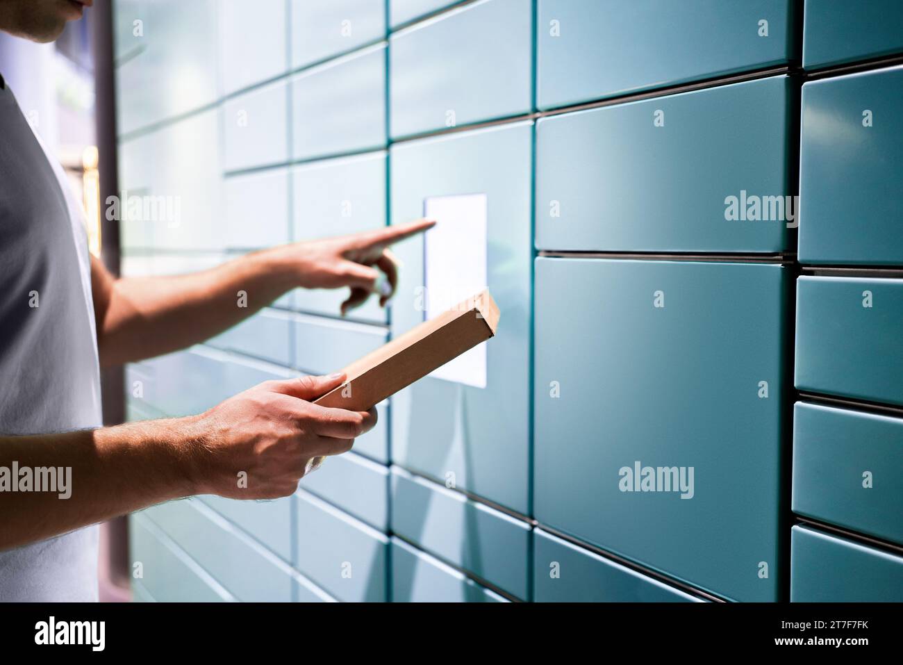 Locker parcel service. Package delivery to post mail box machine. Packet automat in postal office. Man using touchscreen. Pick up at storage. Stock Photo