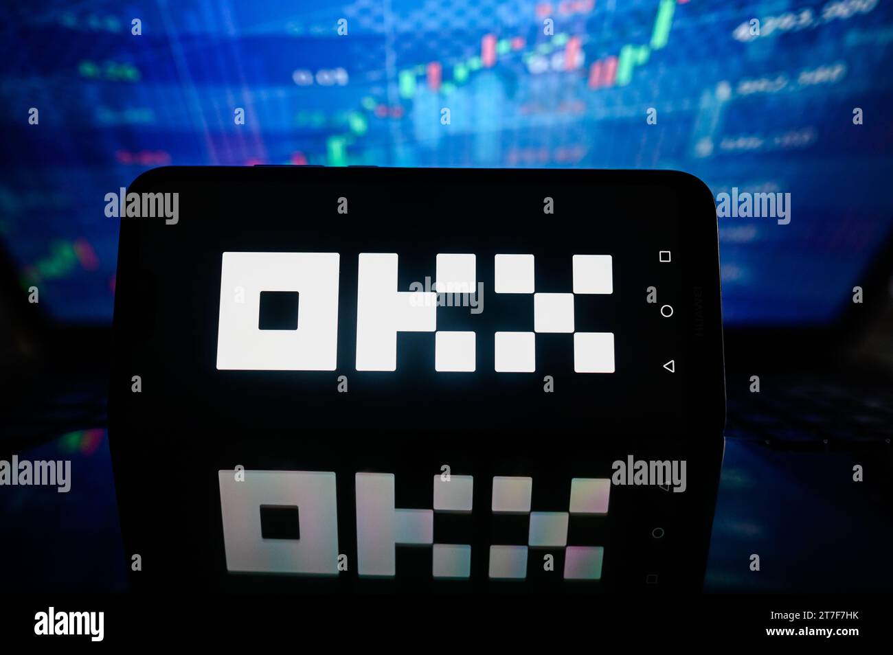 In this photo illustration a OKX logo is displayed on a smartphone with stock market percentages in the background. Stock Photo