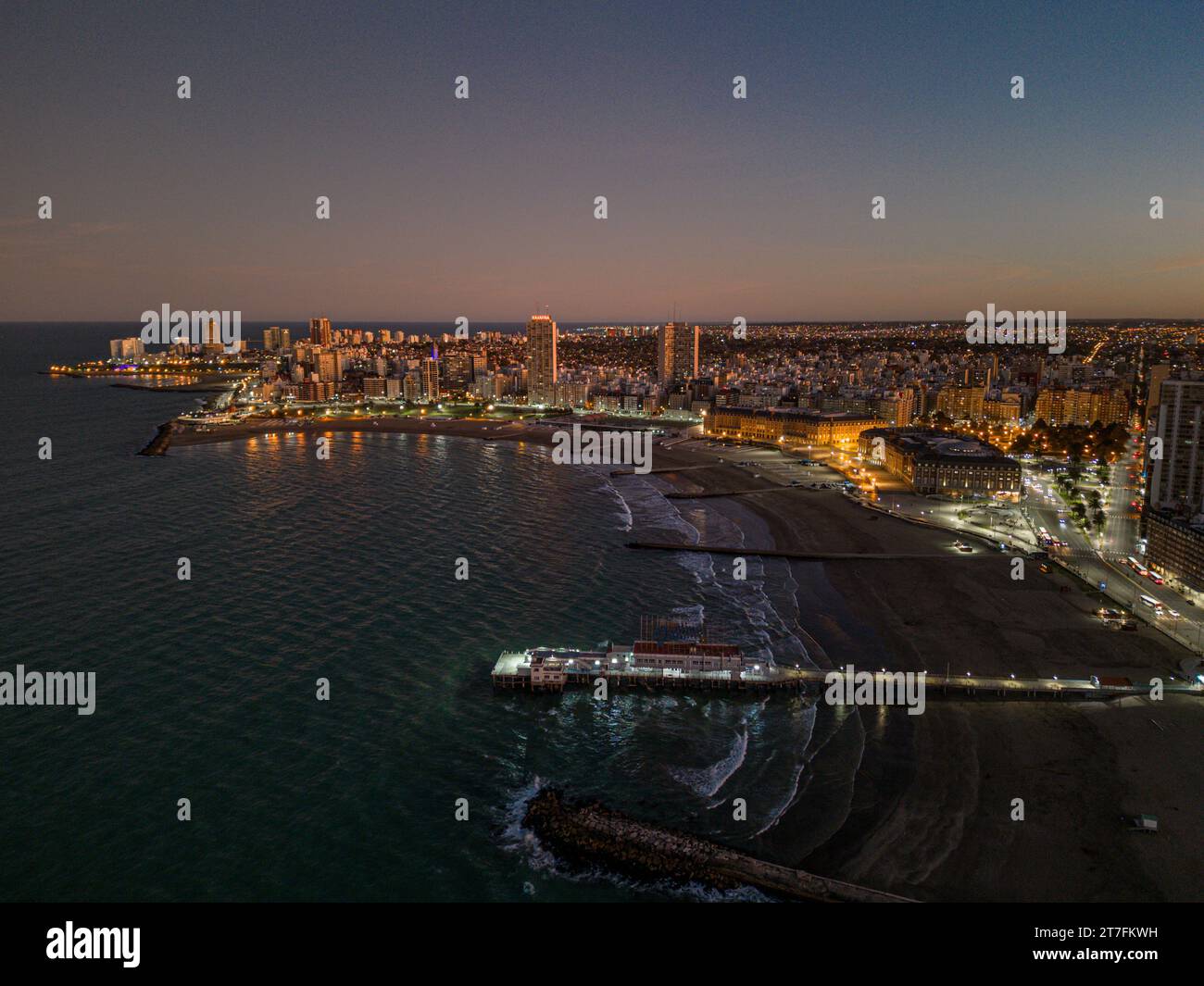 An aerial view of a city skyline at night, illuminated by a multitude ...