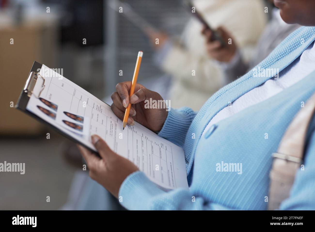 Pasing Manjer Hand of young female applicant with pencil pointing at filled form ...