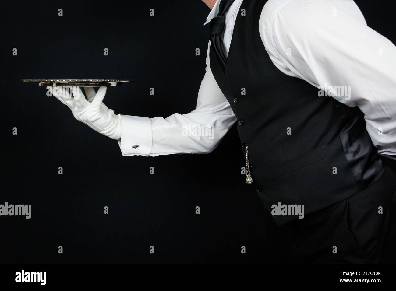 Portrait of Butler or Waiter in White Gloves Holding Silver Serving Tray. Concept of Service Industry and Professional Hospitality. Stock Photo