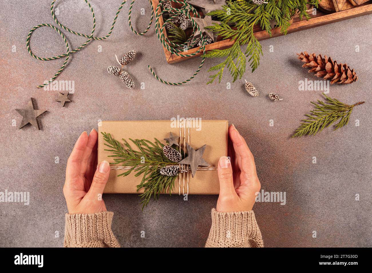 Christmas decor and Womans hands decorating handmade gift box Stock Photo