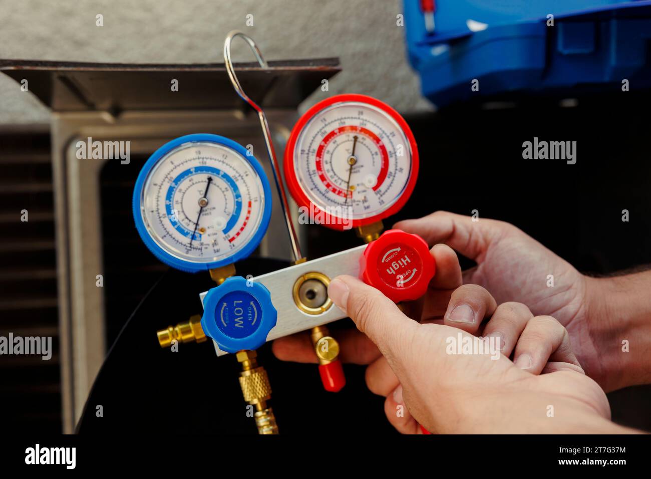 Close up of proficient worker calibrating manifold gauges during