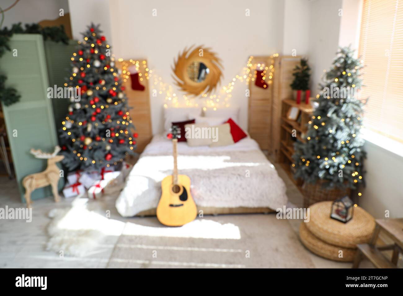 Cozy Christmas bedroom interior with decorated fir trees and guitar Stock Photo