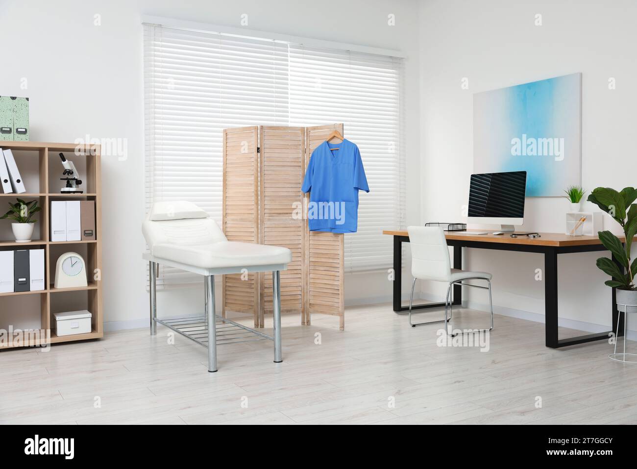 Modern medical office with doctor's workplace and examination table in ...