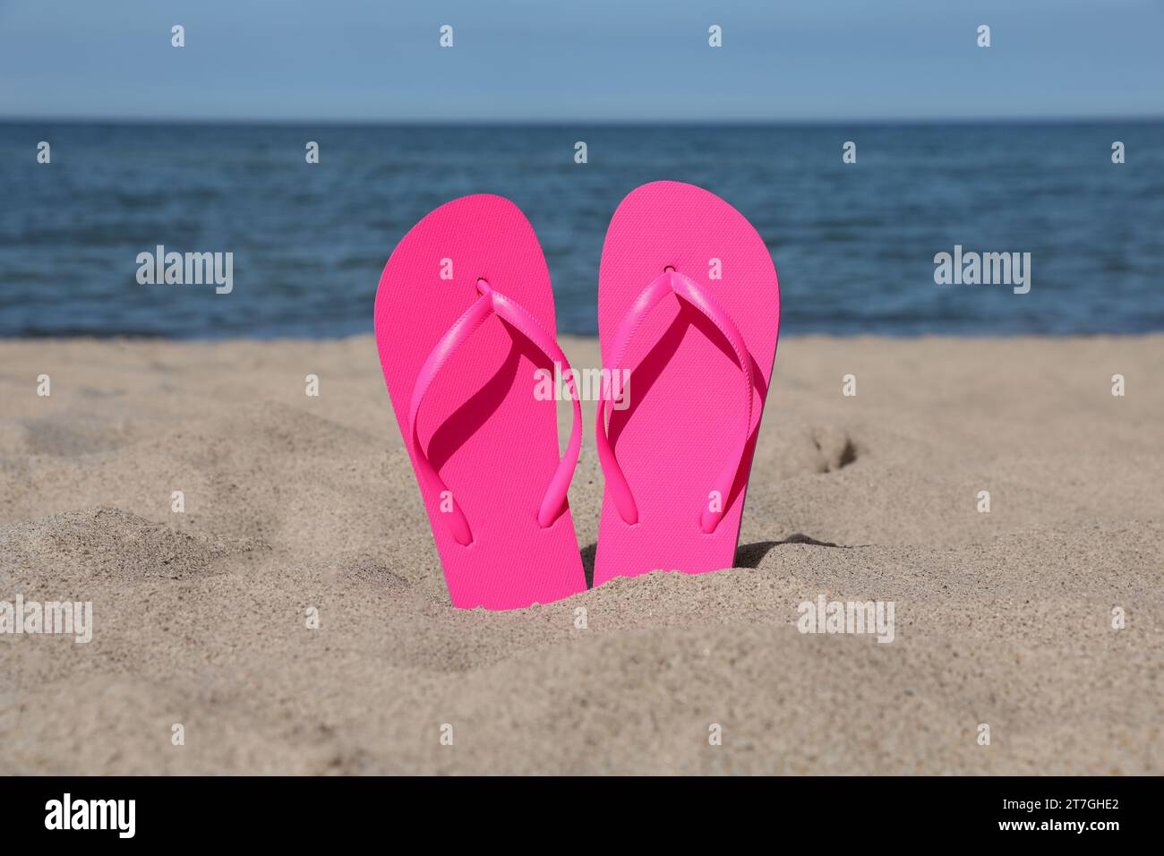 Stylish pink flip flops on beach sand Stock Photo - Alamy