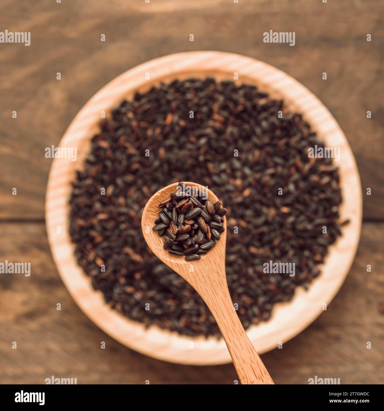 Black organic rice grain spoon bowl wooden backdrop Stock Photo - Alamy